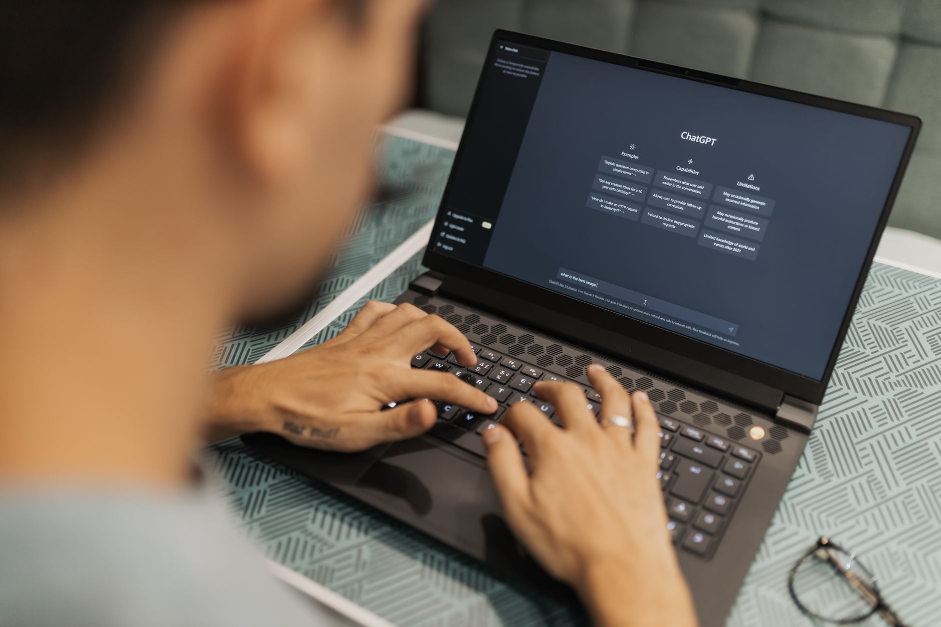 Insurance agent typing on laptop while an AI chat interface displays policy summary text
