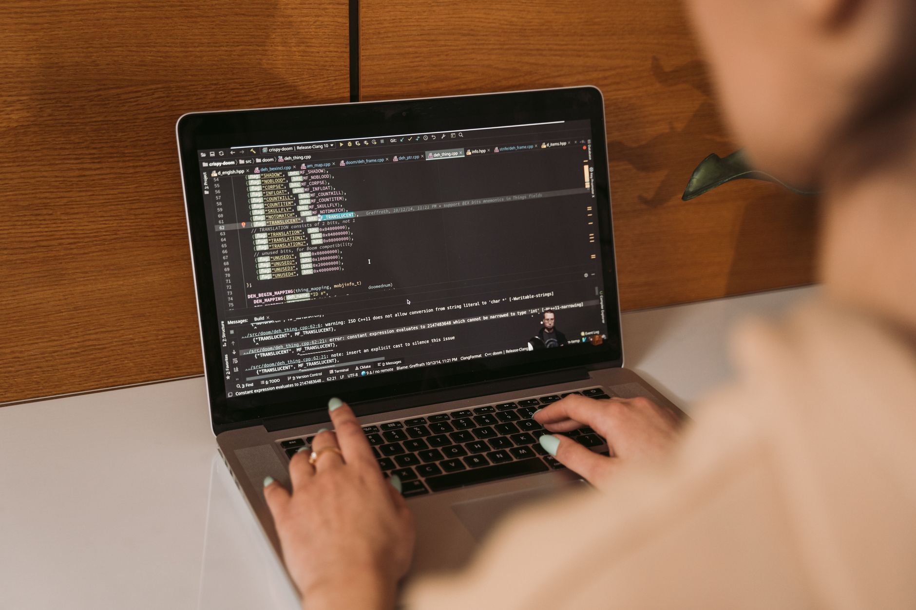 Software developer writing code in an AI-assisted code editor on a laptop